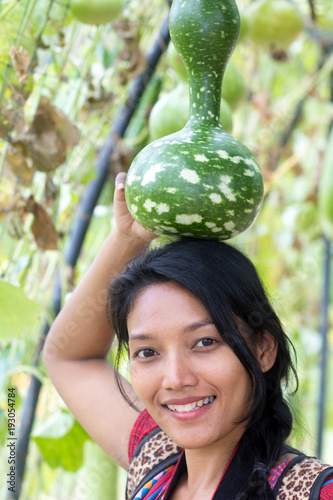 Asian woman holding on her head Lagenaria siceraria (Molina) Standl, Calabash. photo