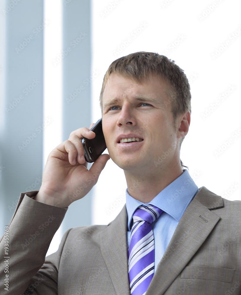 Businessman at the window talking on the phone Businessman at the window talking on the phone