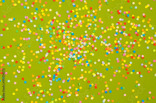 Colorful Confetti in front of green Background.