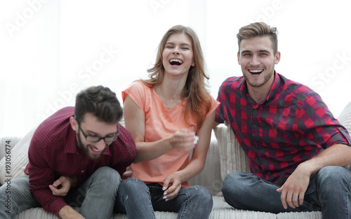 group of young people laughing and sitting on the couch