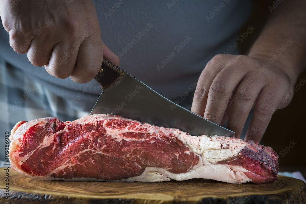 Carnicero cortando carne de ternera para la comida