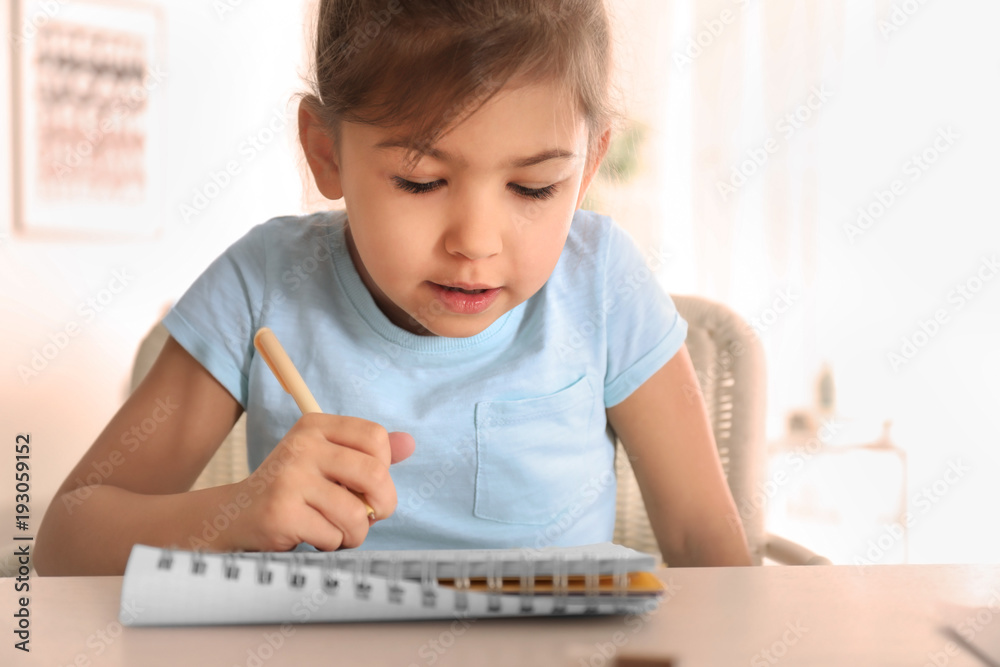 Cute little girl doing homework indoors Cute little girl doing homework indoors