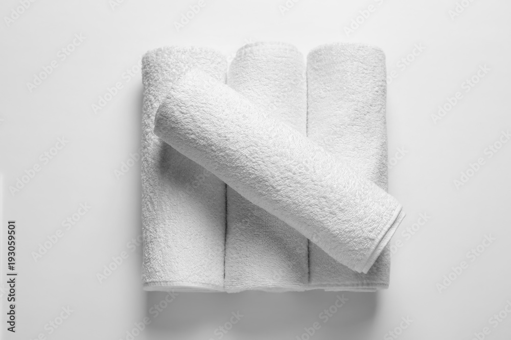 Fototapeta premium Rolled clean terry towels on white background, top view