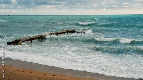Lonely pier in the Adriatic Sea big waves photo