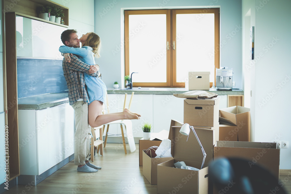 Portrait of young couple moving in new home. Young couple