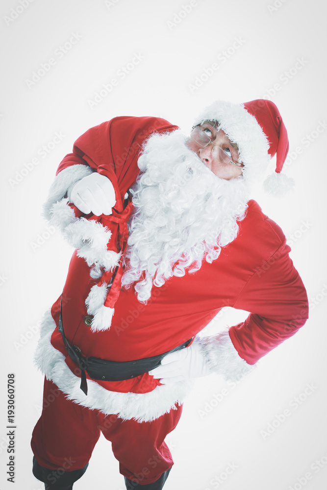 Real Santa Claus carrying big bag full of gifts, isolated on white background.