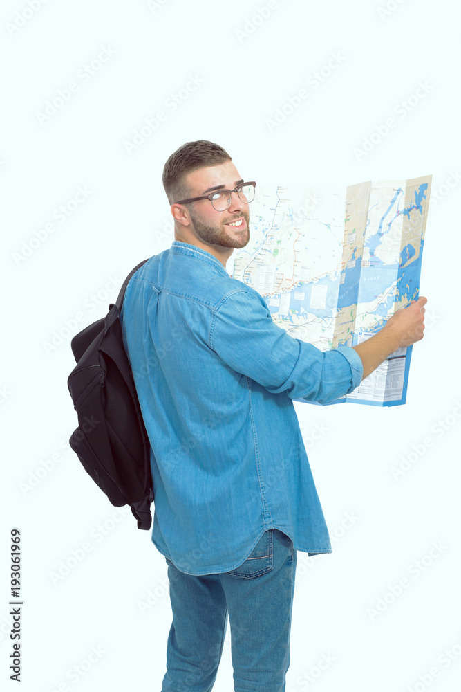 Young man holding at map on white background. Young man holding a map on a white background. A tourist on vacations. Looking for sights. Adventures seeker. Young man holding at map on white background. Young man holding a map on a white background. A tourist on vacations. Looking for sights. Adventures seeker.