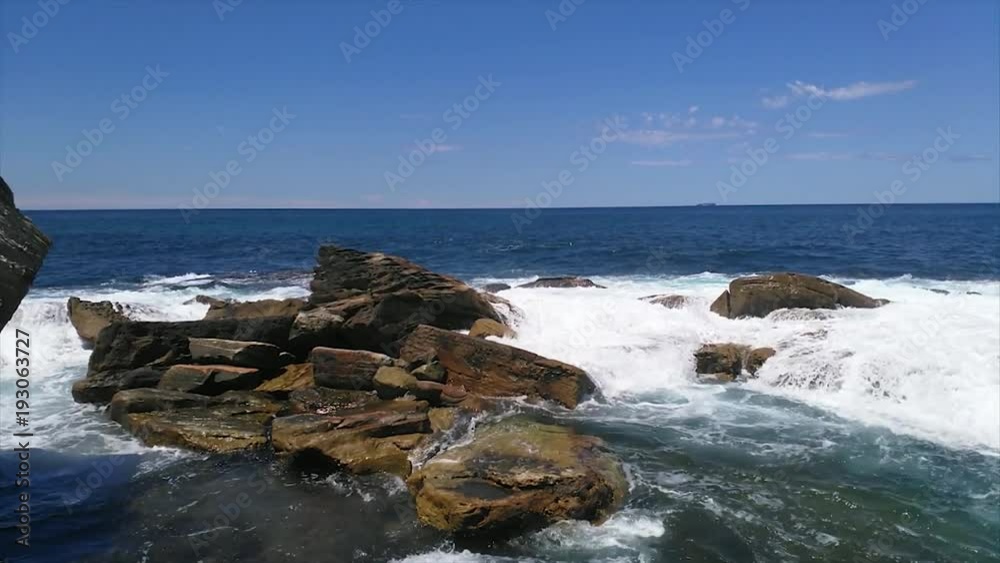Waves hitting clips, near Coogee beach, on a sunny summer day, in Sydney, Australia