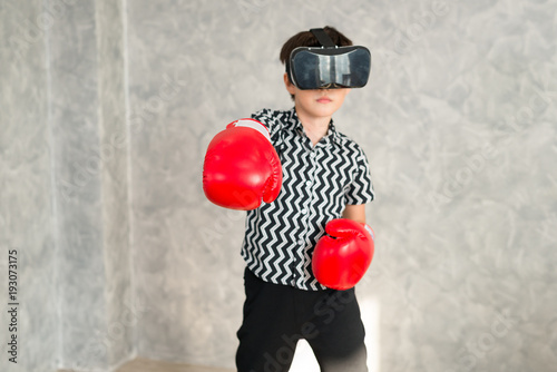 A boy is playing boxing game with 3D virtual reality headset..