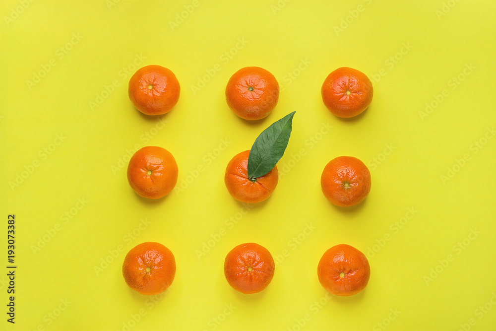 Bright Ripe Tangerines Arranged in Rows in Square One with Green Leaf in Middle. Yellow Background. Food Knolling. Styled Creative Image. Tropical Fruit Vacation Summer Vegan Concept Bright Ripe Tangerines Arranged in Rows in Square One with Green Leaf in Middle. Yellow Background. Food Knolling. Styled Creative Image. Tropical Fruit Vacation Summer Vegan Concept