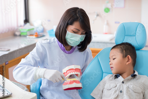 Asian female dentist talking to brush teeth properly explained to the boys were listening to in the hospital