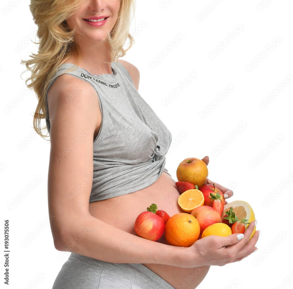 Beautiful pregnant woman with fresh fruits. Pregnancy motherhood expectation healthy eating and weight control concept Beautiful pregnant woman with fresh fruits. Pregnancy motherhood expectation healthy eating and weight control concept