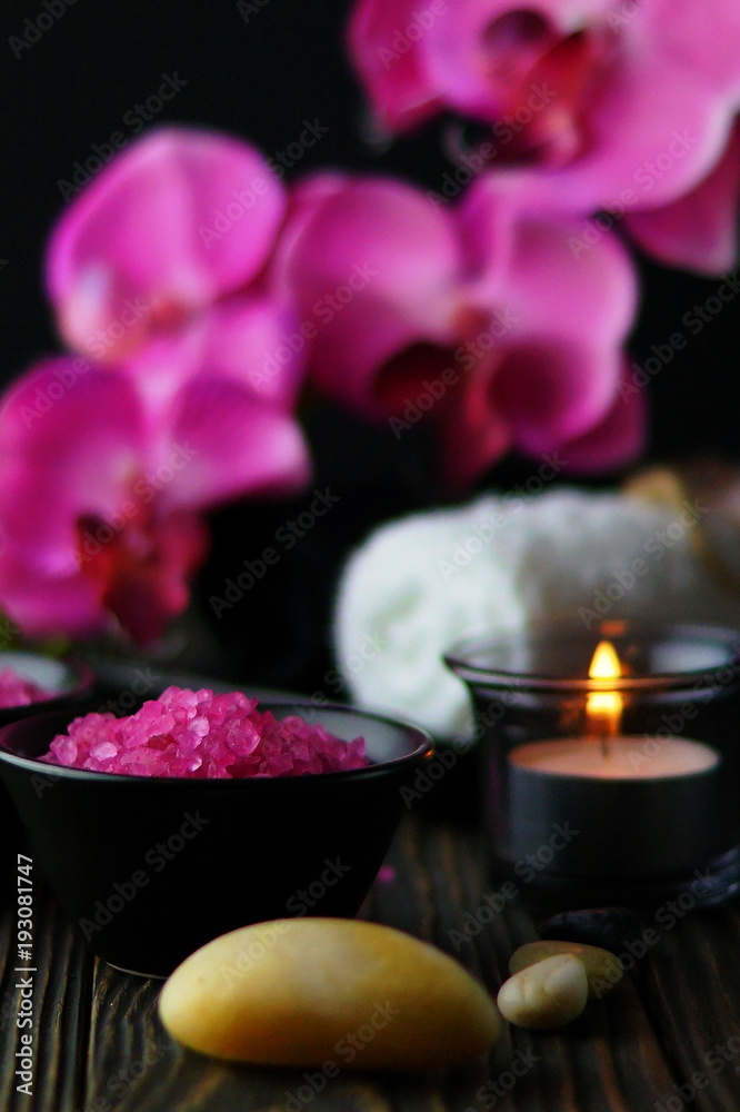 Composition of spa treatment on dark wooden background. Pink massage sea salt and orchids. Copy space Composition of spa treatment on dark wooden background. Pink massage sea salt and orchids. Copy space