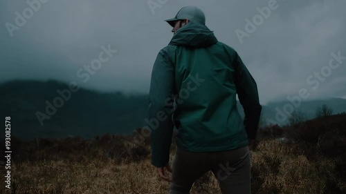 Man Walking in a Dark Misty Mountain Field