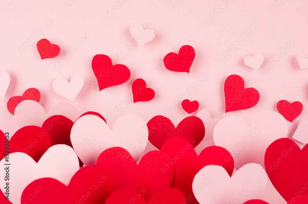 Valentine day background. Stream of fly out red and pink paper hearts on pink color backdrop..