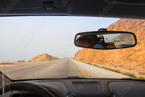 Fototapeta Naklejka Na Ścianę i Meble -  Desert highway and mountains through car window not far from Dead sea