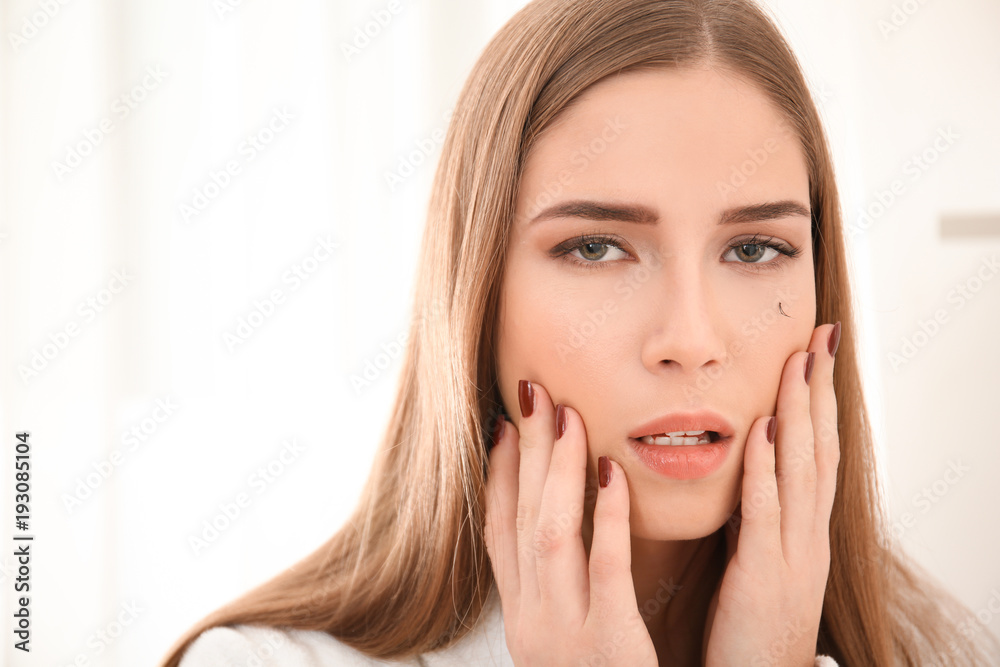 Young woman with eyelash loss problem on light background Young woman with eyelash loss problem on light background