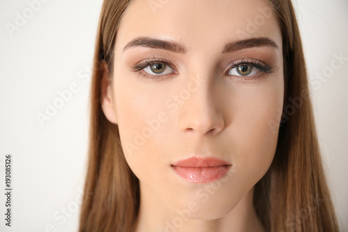 Young woman with eyelash loss problem on white background