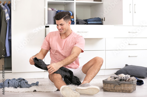 Man picking outfit while si...