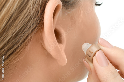 Young woman putting hearing...