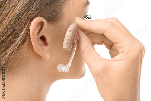 Young woman putting hearing...