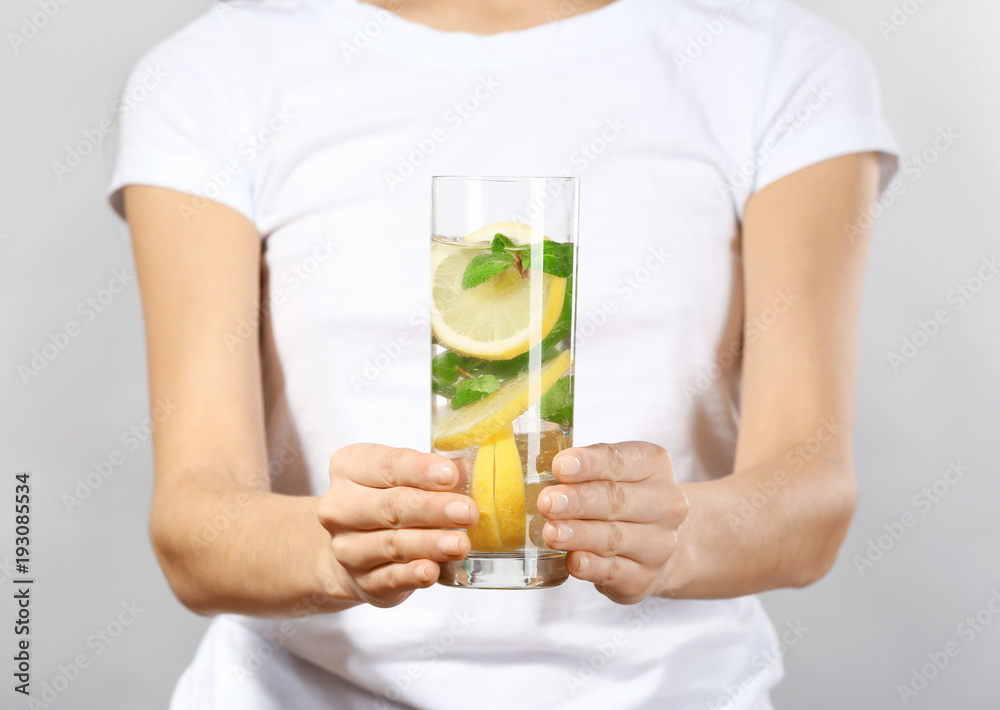 Young woman with glass of lemonade on grey background, closeup Young woman with glass of lemonade on grey background, closeup