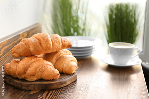 Delicious croissants on wooden board