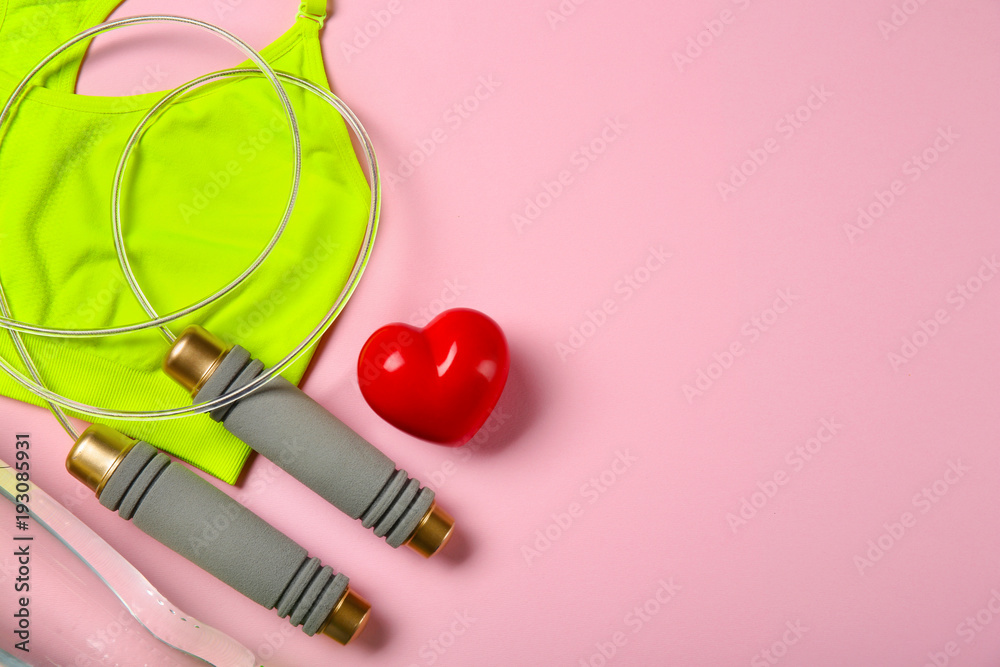 Gym stuff and red heart on color background. Cardio training