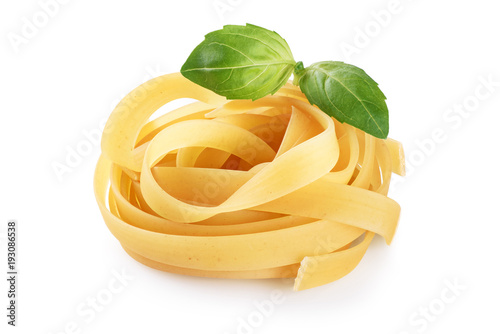 Raw tagliatelle pasta and basil isolated on white background.