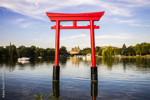 The Japanese torii in the Plan d'Eau Saint-Symphorien, Saulcy, Metz, France, with the Gothic cathedral of Saint Stephen in the background