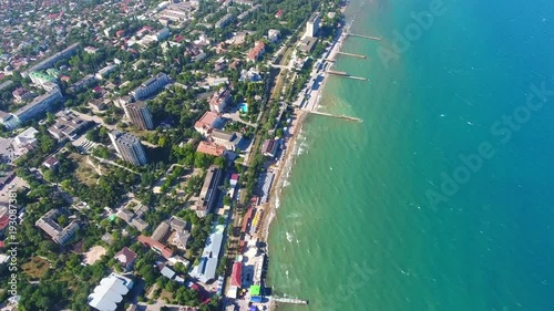 Aerial view: Sea, beach, sea, resort town of Feodosiya, Crimea vacation on Black sea. Dreamland beach from aero view tourists relaxing and swim, city aerial pan tilt up Cremea black sea beach Feodosia photo