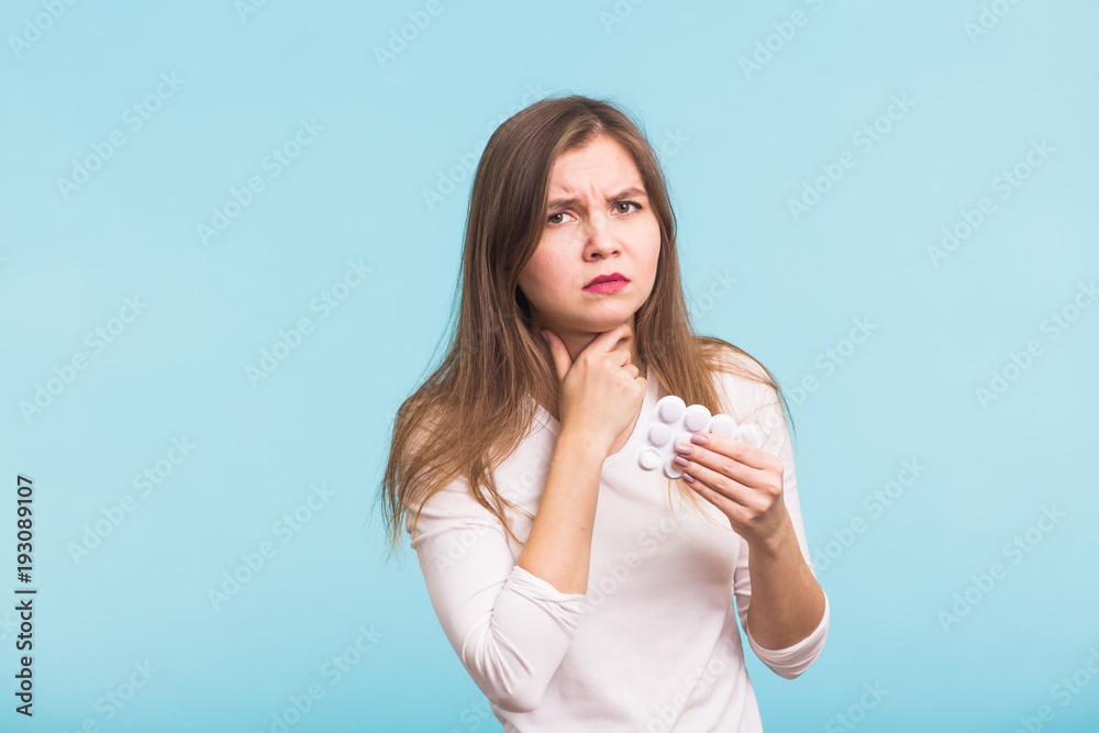 Sore throat. Woman touching the neck on blue background Sore throat. Woman touching the neck on blue background