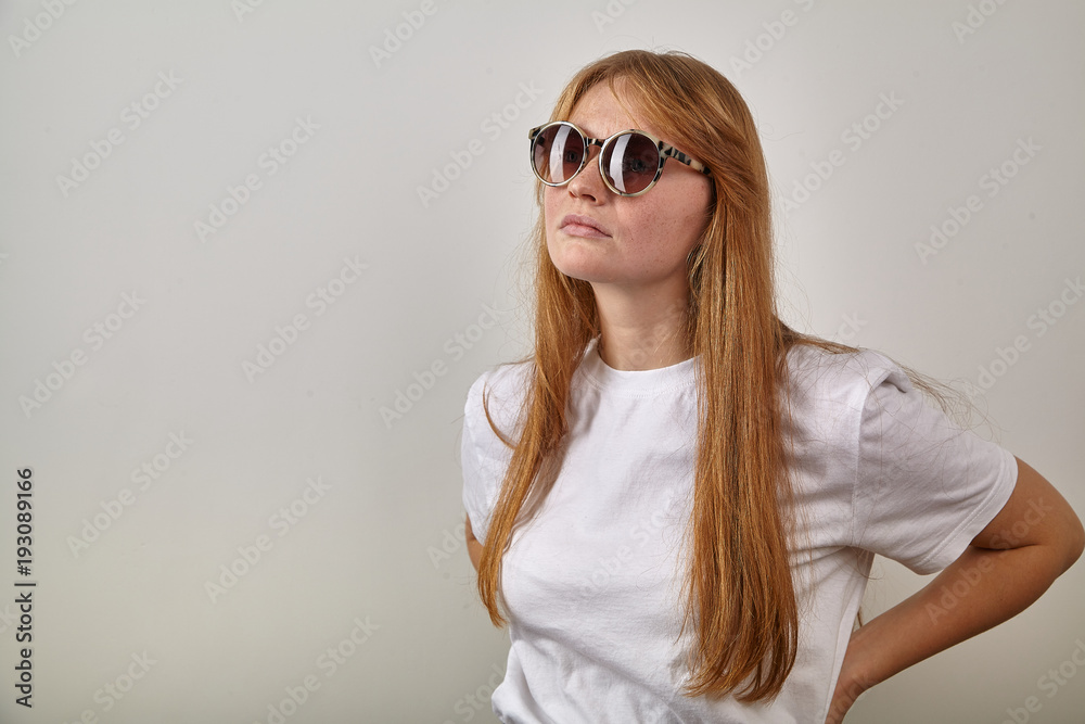 Horizontal headshot of young red-headed girl wearing sunglasses with leopard pattern on earpieces Horizontal headshot of young red-headed girl wearing sunglasses with leopard pattern on earpieces