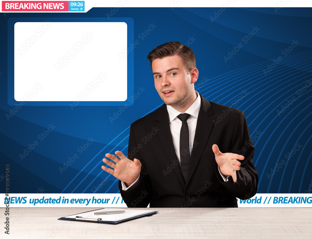 Television reporter telling breaking news at his studio desk with copy space Television reporter telling breaking news at his studio desk with copy space