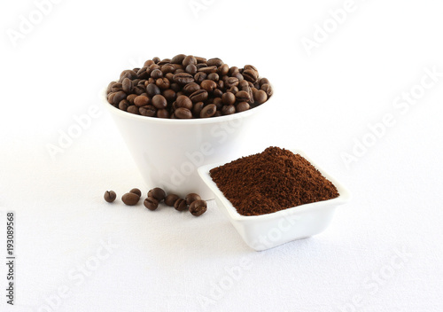 Coffee beans and powder, which is freshly ground, in bowls.