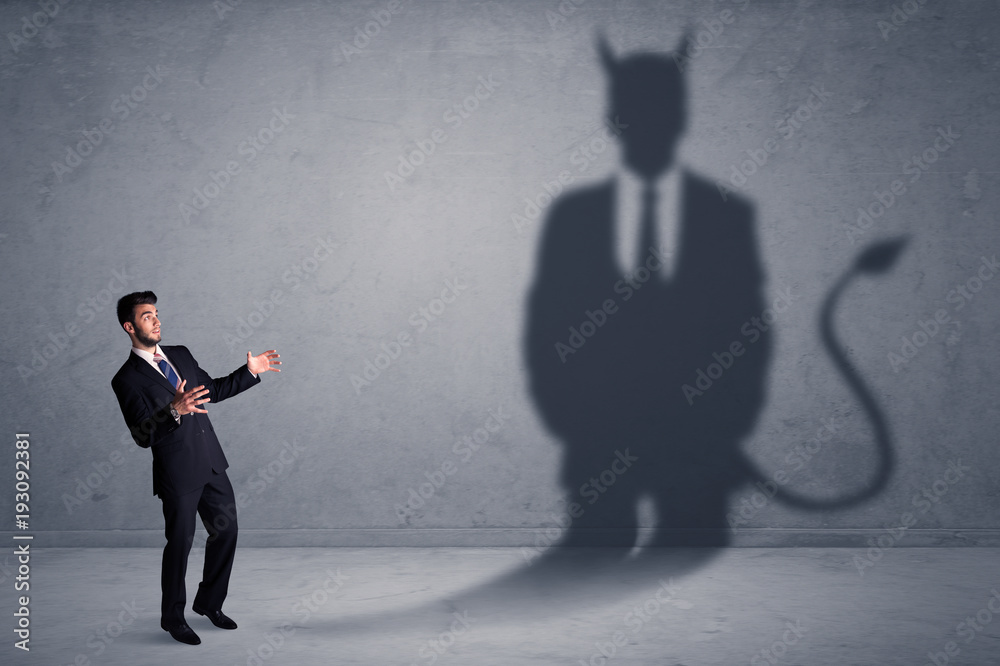 Fototapeta premium Business man looking at his own devil demon shadow concept