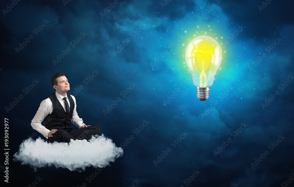 Man sitting on cloud looking at a lightbulb Man sitting on cloud looking at a lightbulb