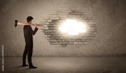 Business man hitting brick wall with hammer and opening a hole