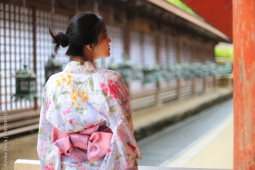a young Japanese woman in summer kimomo (yukata) with traditional lanterns in a traditional Japanese building