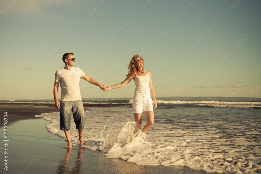 Romantic happy  man and woman couple walking on a  beach