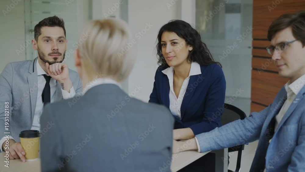 Business team chatting while sitting in modern office indoors during coffee break Business team chatting while sitting in modern office indoors during coffee break