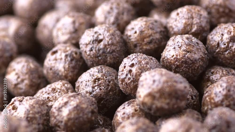 Chocolate crunchy cereals closeup macro revolving on a turntable. Shallow depth of field. Low angle. Not loopable. Colors out of camera. No color grading. Chocolate crunchy cereals closeup macro revolving on a turntable. Shallow depth of field. Low angle. Not loopable. Colors out of camera. No color grading.