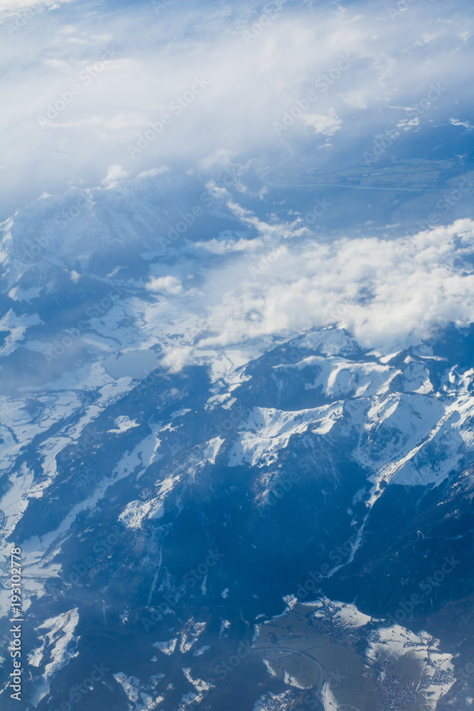 Obraz premium Snowy and cloudy scenic mountains scene from above
