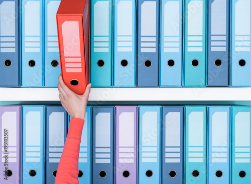 Office worker taking a folder in the archive photo