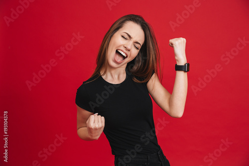 Fotografie Portrait of ecstatic woman 20s wearing black t-shirt screaming and clenching fis
