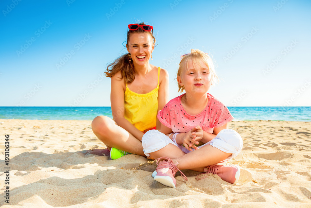 happy trendy mother and daughter in colorful clothes on beach happy trendy mother and daughter in colorful clothes on beach