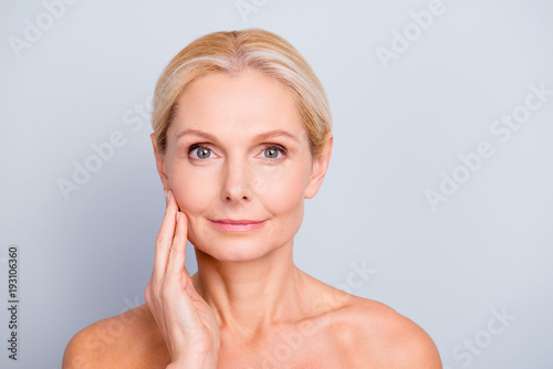 Portrait of pretty, attractive, charming, naked, nude woman touching her  perfect skin, isolated on grey background,  after peeling, lotion, mask, perfection, wellness, wellbeing, hydration concept