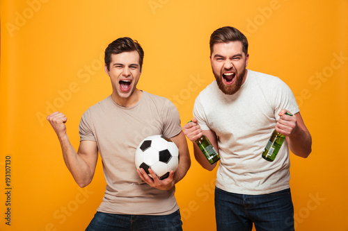 Portrait of a two happy young men holding beer bottles