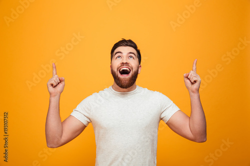 Portrait of a happy bearded man pointing fingers up photo