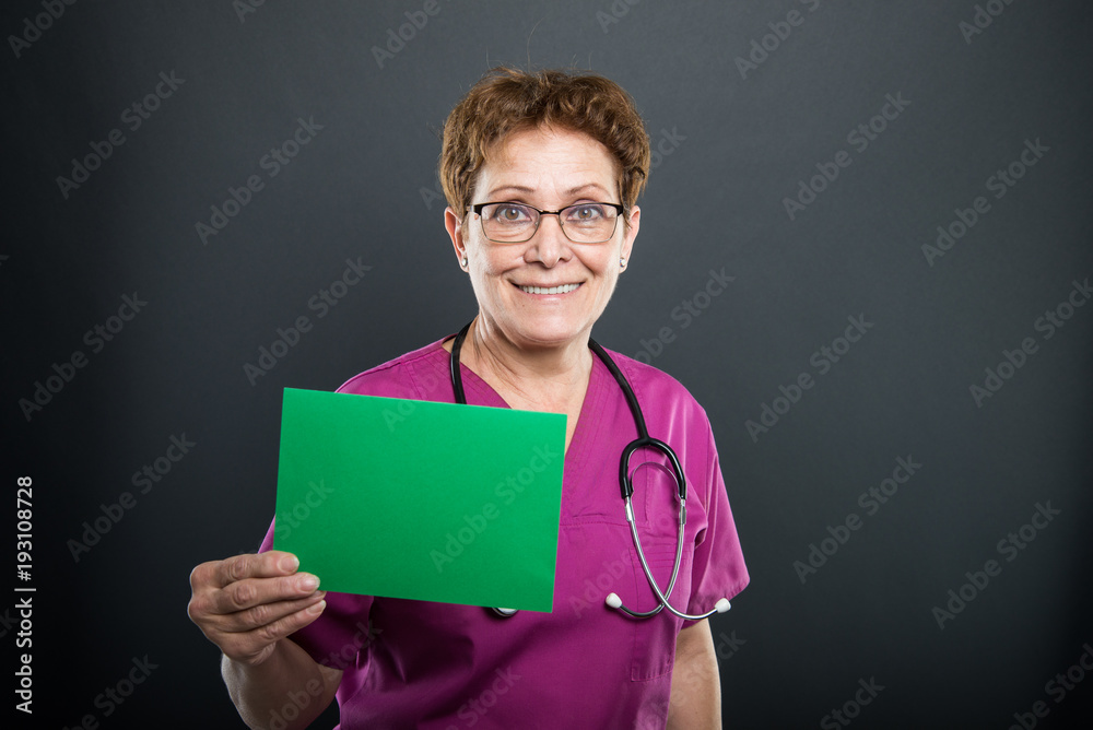 Portrait of senior lady doctor showing green board Portrait of senior lady doctor showing green board